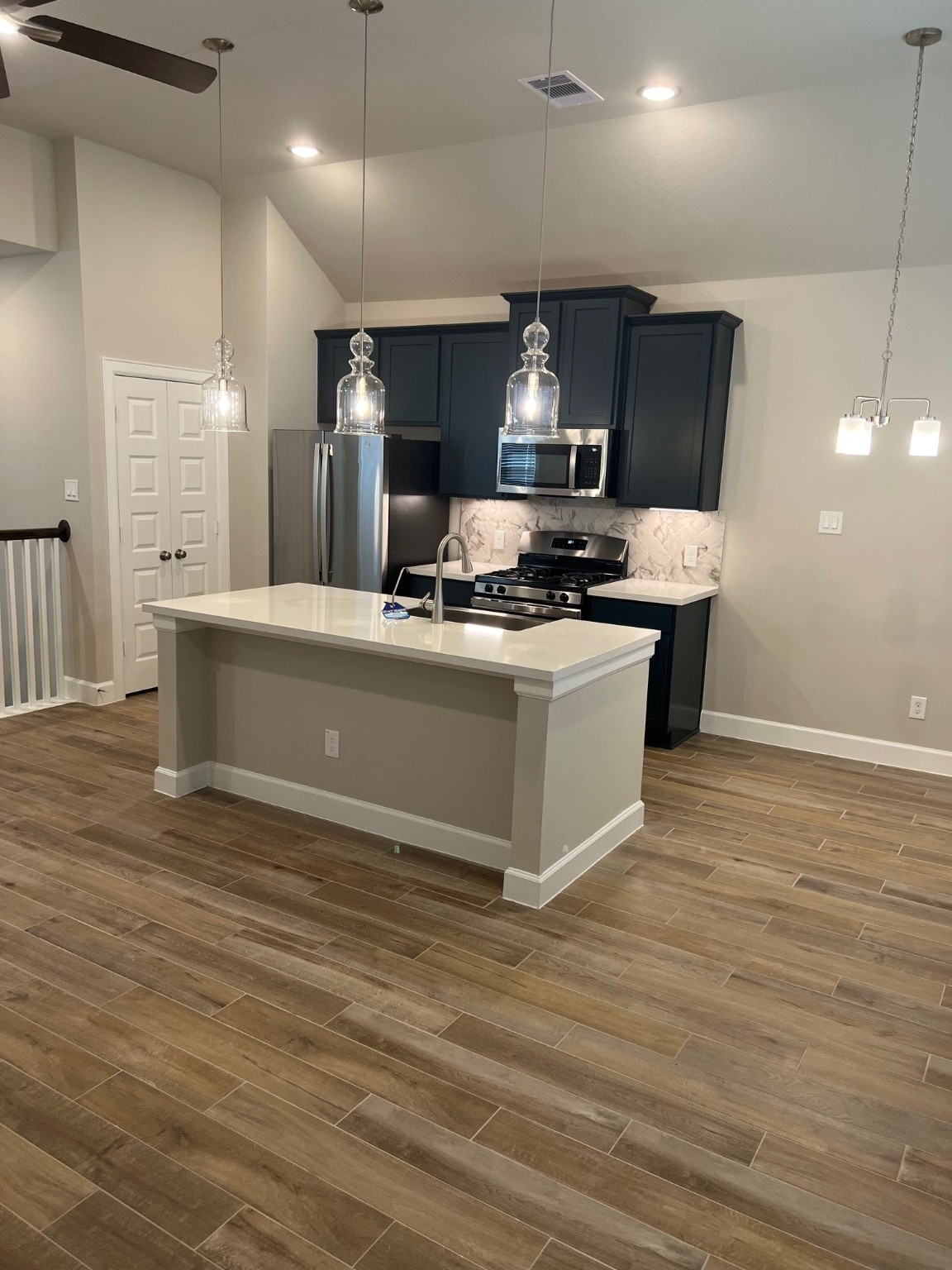 3316 Vine Ter Trace Houston, TX 77047 - Photo 11 of 18 a large kitchen with stainless steel appliances a large counter top a stove and a wooden floors