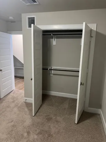 an empty room with wooden door and cabinet