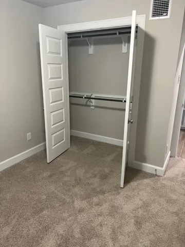 a large kitchen with stainless steel appliances a large counter top a stove and a wooden floors