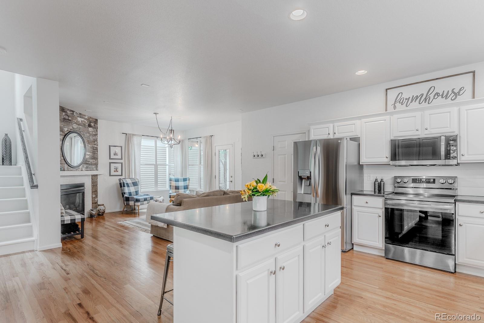 8367 Devinney Street Arvada, CO 80005 - Photo 5 of 41 a kitchen with stainless steel appliances a stove a sink a refrigerator a center island and a refrigerator