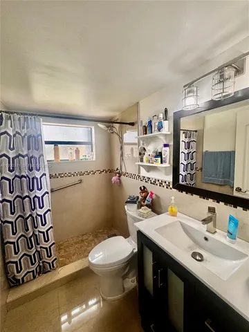 a bathroom with a sink toilet and mirror