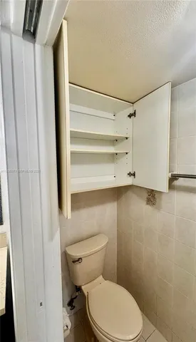 a bathroom with a granite countertop shower and a toilet