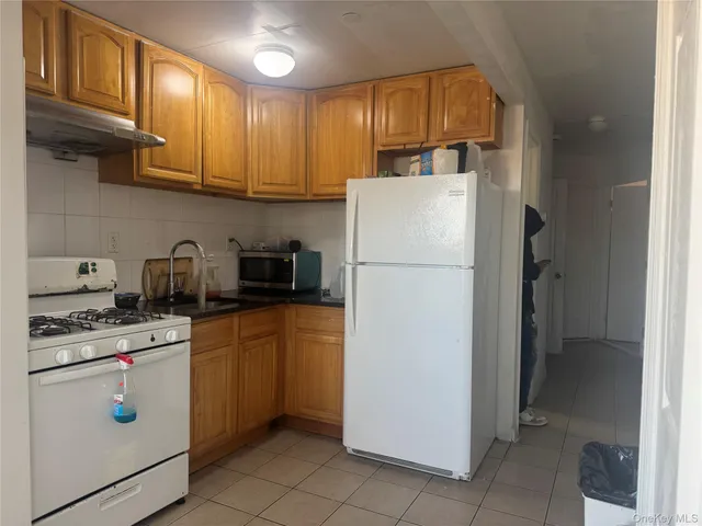 a kitchen with a refrigerator sink and cabinets