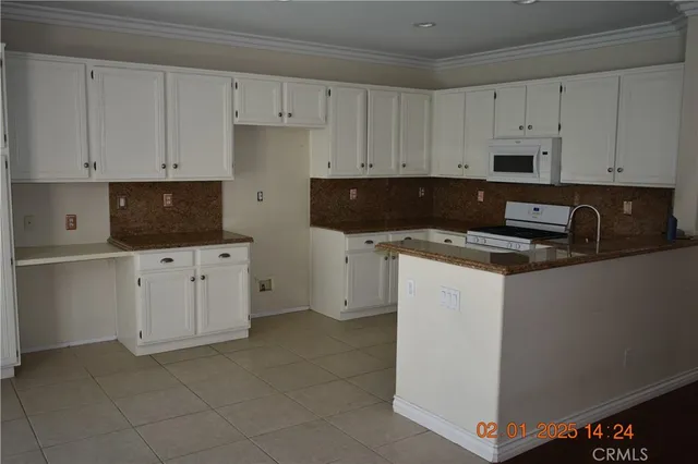 a kitchen with granite countertop white cabinets and stainless steel appliances