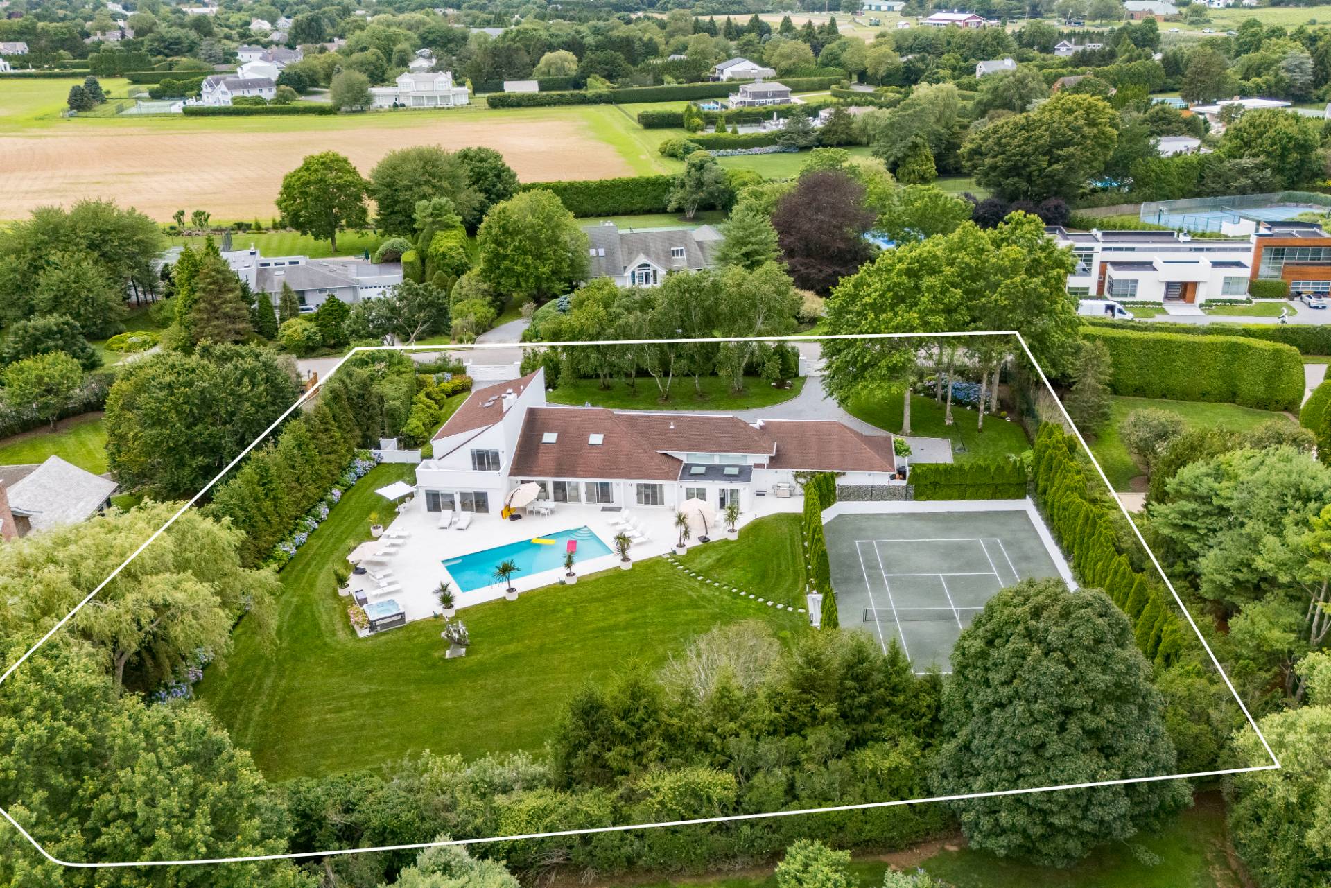 an aerial view of a house with a garden and lake view