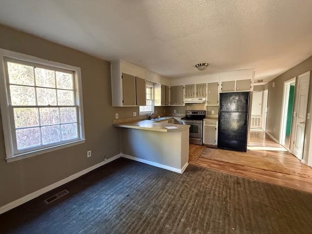 40 Sampson Road Hemingway, SC 29554 - Photo 3 of 12 Kitchen with freestanding refrigerator, electric range, light countertops, a textured ceiling, and a peninsula