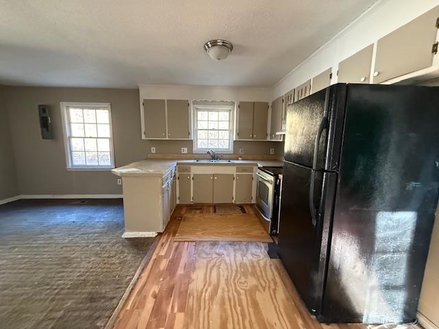 40 Sampson Road Hemingway, SC 29554 - Photo 5 of 12 Kitchen featuring freestanding refrigerator, light countertops, stainless steel electric stove, light wood-type flooring, and a peninsula