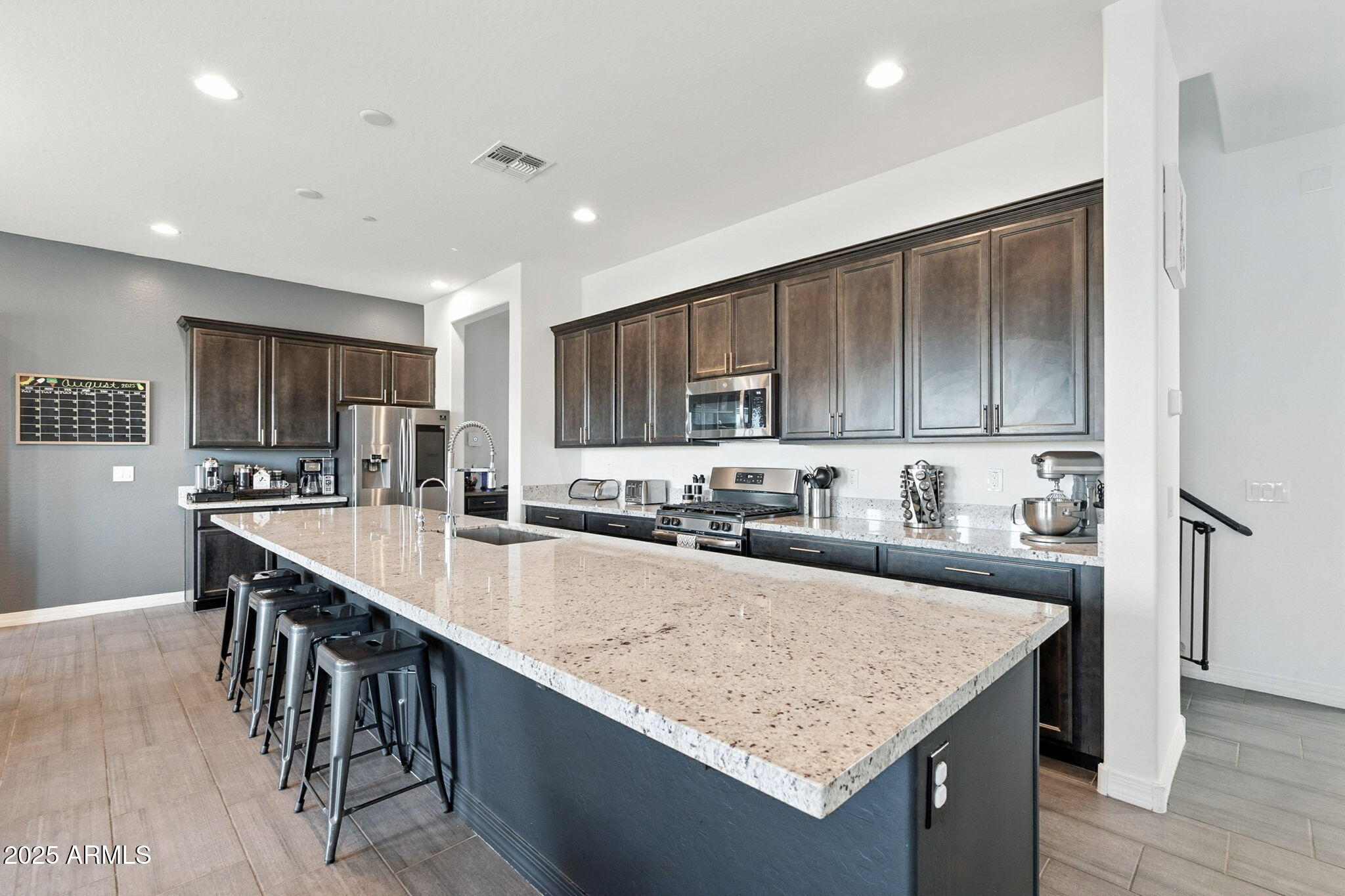 7236 West Phelps Road Peoria, AZ 85382 - Photo 19 of 53 a kitchen with stainless steel appliances granite countertop counter space and wooden cabinets
