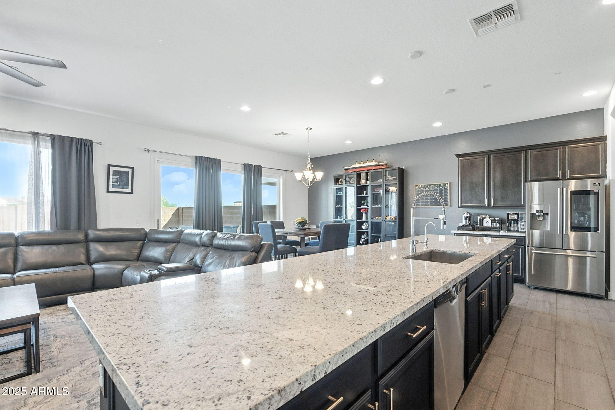 7236 West Phelps Road Peoria, AZ 85382 - Photo 21 of 53 a large kitchen with stainless steel appliances granite countertop a lot of counter space and living room