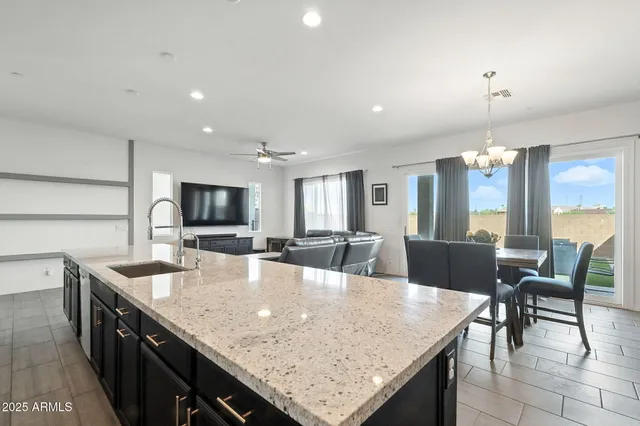 a dining table with kitchen island granite countertop a table chairs and a kitchen view