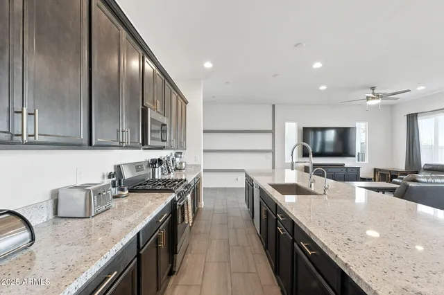 a kitchen with lots of counter top space sink and stainless steel appliances