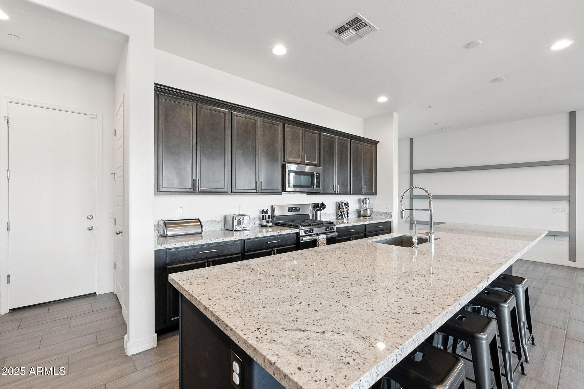 7236 West Phelps Road Peoria, AZ 85382 - Photo 25 of 53 a kitchen with granite countertop a table chairs sink and cabinets