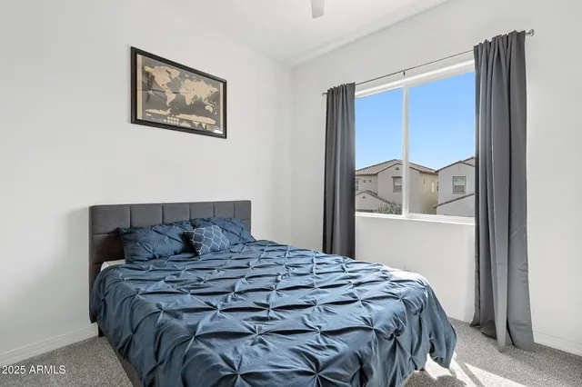 a large bed sitting in a bedroom next to a window