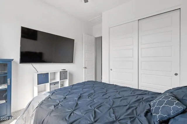 a bedroom with a bed and a flat screen tv