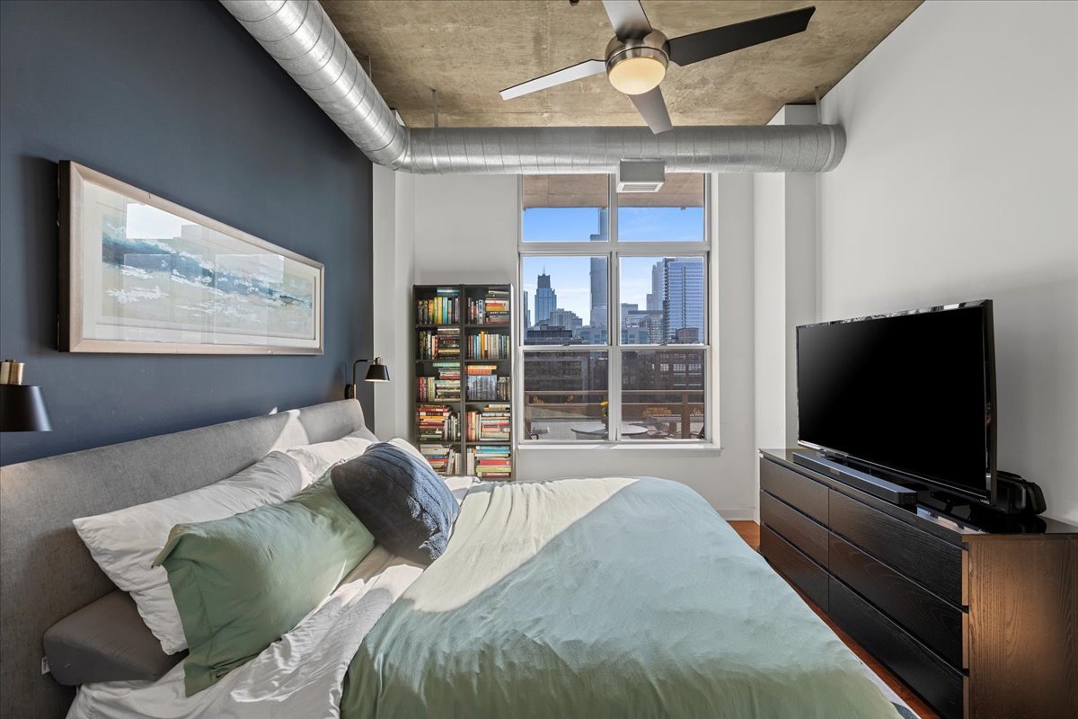 111 South Morgan Street, Unit 823 Chicago, IL 60607 - Photo 12 of 20 a bedroom with furniture and a flat screen tv