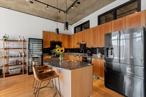 a kitchen with stainless steel appliances granite countertop a refrigerator and a stove