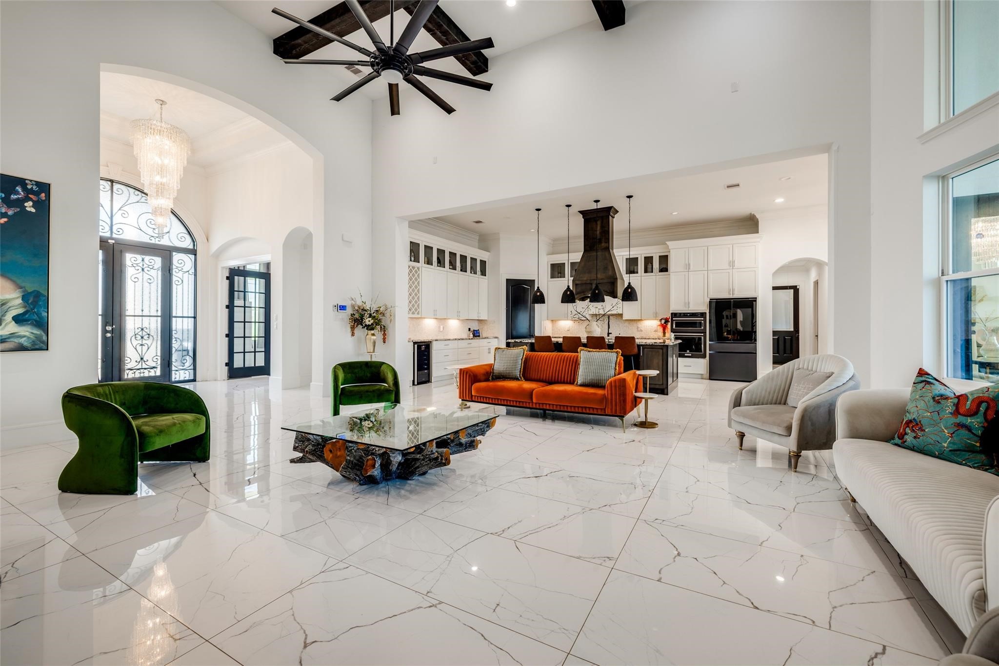 4821 Walters Road Richmond, TX 77469 - Photo 22 of 50 a perfect blend of modern luxury and warmth, highlighted by soaring vaulted ceilings with exposed beams, oversized windows that flood the home with natural light, and elegant designer finishes throughout. The open-concept layout features a striking floor-to-ceiling fireplace, custom built-ins, and seamless flow into the gourmet kitchen and dining areas, creating an ideal setting for both everyday living and entertaining. Thoughtfully curated furnishings, rich wood accents, and sophisticated lighting