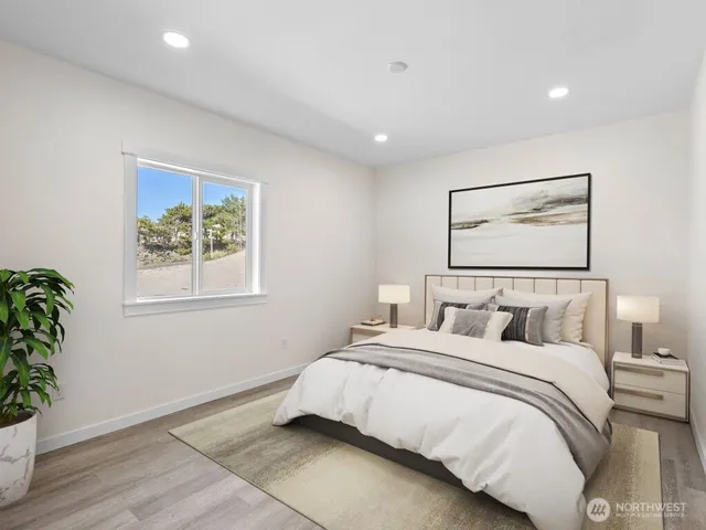 a bedroom with a large bed and a potted plant