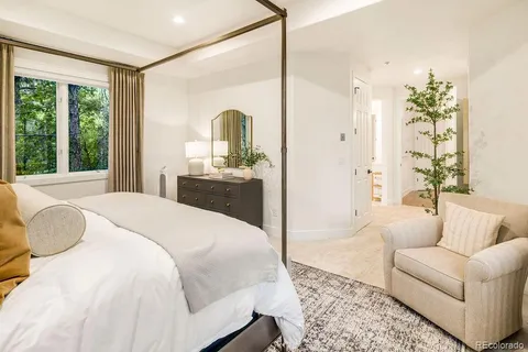 a spacious bedroom with a bed a couch and a large window