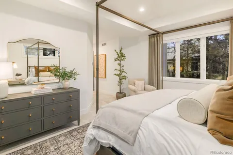 a spacious bedroom with a bed and wooden floor