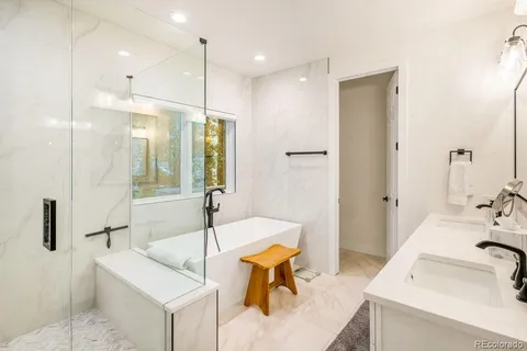 a bathroom with a tub sink and mirror