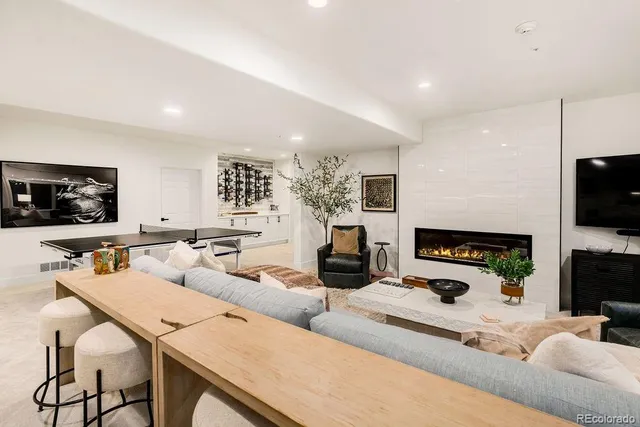a spacious bedroom with a bed a couch and a potted plant on table