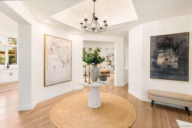 a dining room with chandelier and wooden floor