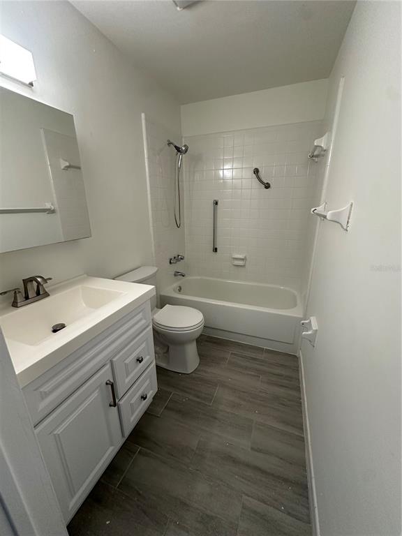 250 Rosery Road Northwest, Unit 227 Largo, FL 33770 - Photo 14 of 18 a bathroom with a double vanity sink toilet a mirror and shower