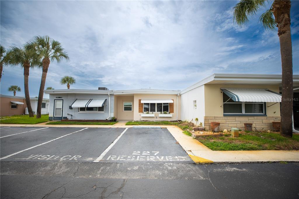 250 Rosery Road Northwest, Unit 227 Largo, FL 33770 - Photo 16 of 18 a front view of a house with a yard and garage