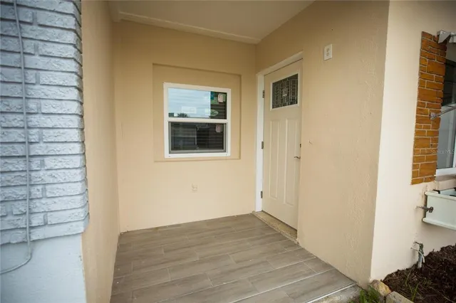 a view of a hallway with wooden floor and a bathroom