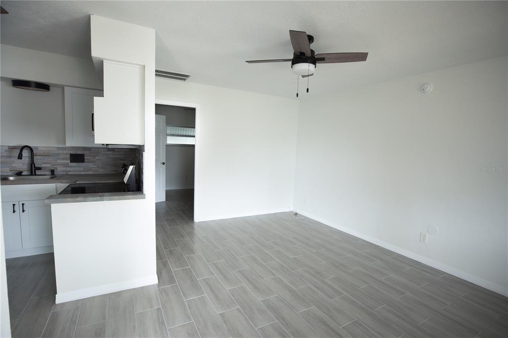 250 Rosery Road Northwest, Unit 227 Largo, FL 33770 - Photo 2 of 18 a kitchen with cabinets wooden floor and a ceiling fan