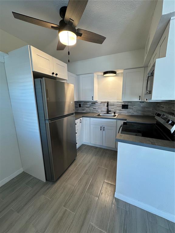 250 Rosery Road Northwest, Unit 227 Largo, FL 33770 - Photo 5 of 18 a kitchen with granite countertop a refrigerator and a stove top oven