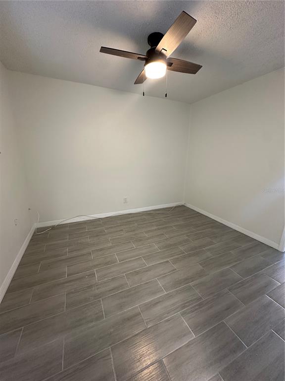 250 Rosery Road Northwest, Unit 227 Largo, FL 33770 - Photo 10 of 18 an empty room with a ceiling fan and carpet