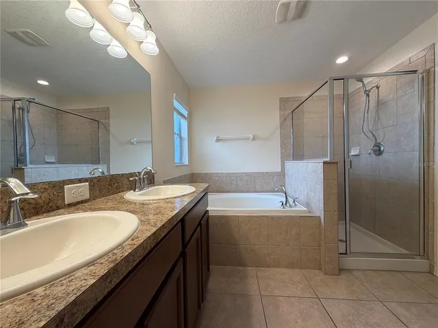 a bathroom with a granite countertop sink a mirror and a bathtub
