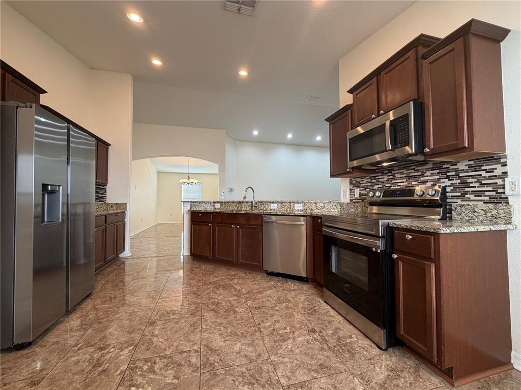 10214 Summer Azure Drive Riverview, FL 33578 - Photo 9 of 23 a kitchen with stainless steel appliances and a refrigerator