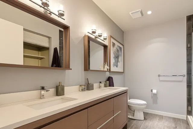 a bathroom with a granite countertop sink mirror and toilet