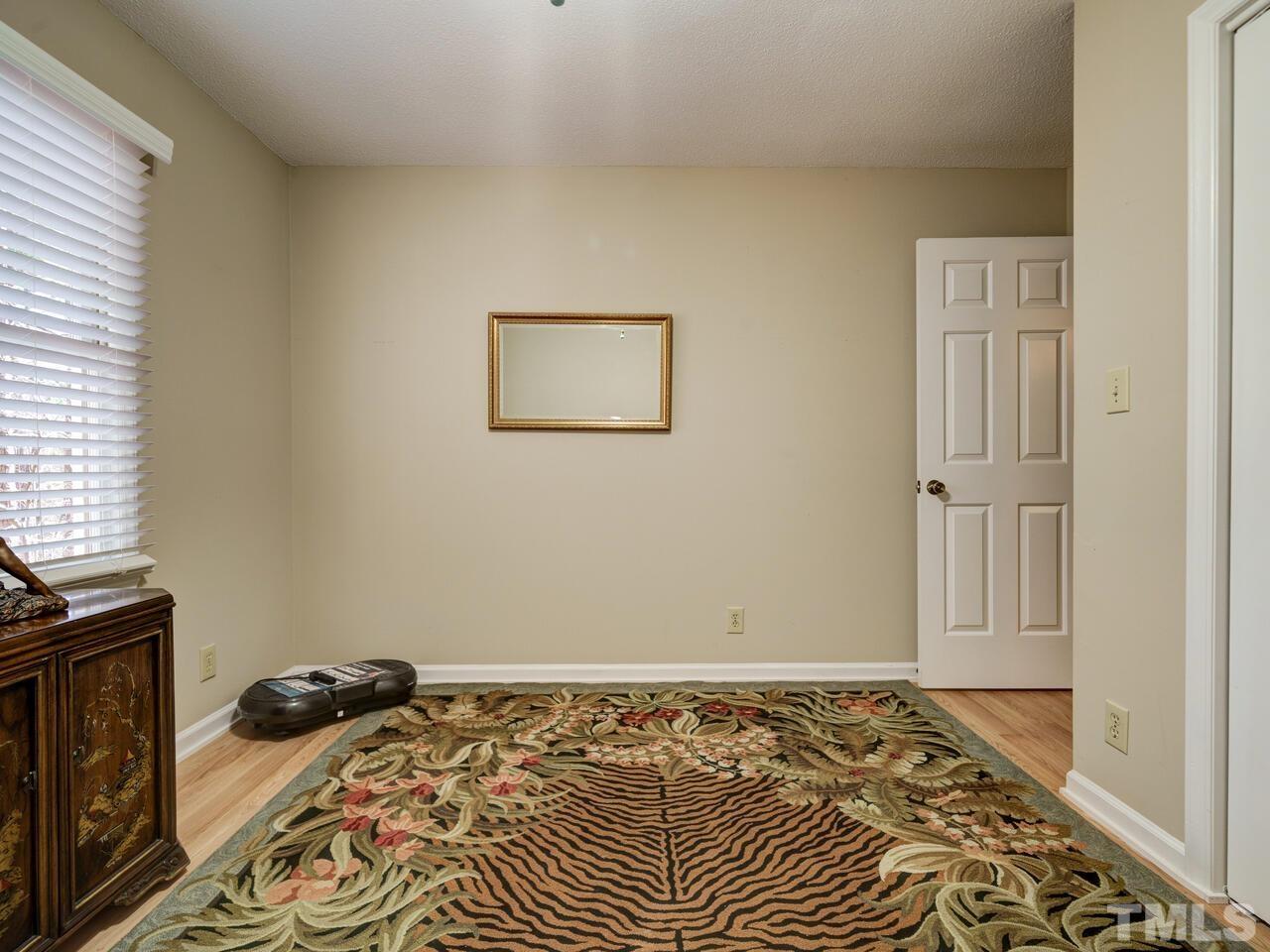 5933 Dunbarton Way Raleigh, NC 27613 - Photo 28 of 48 a bedroom with a bed and wooden floor