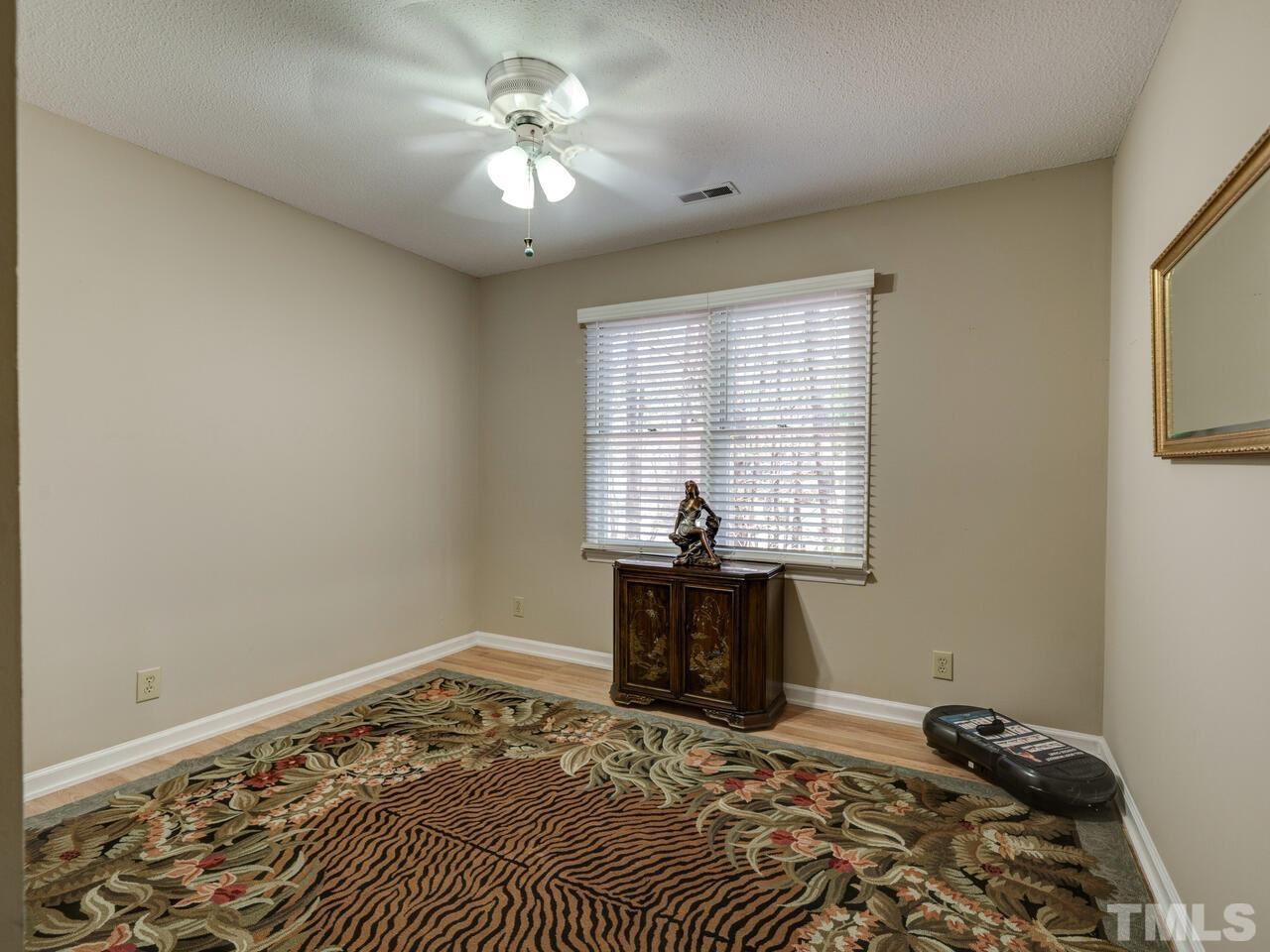 5933 Dunbarton Way Raleigh, NC 27613 - Photo 29 of 48 a bedroom with a bed and a chandelier