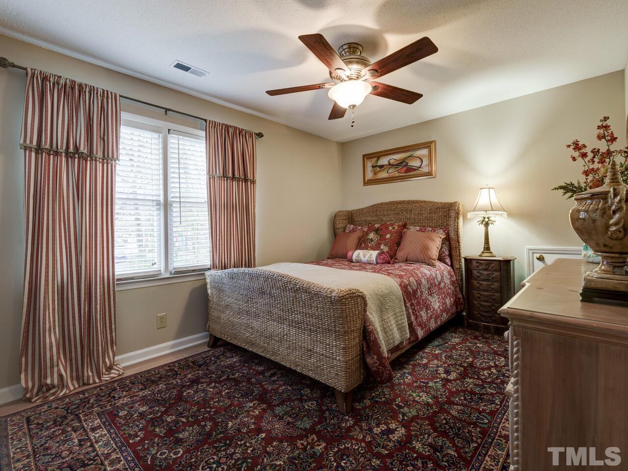 5933 Dunbarton Way Raleigh, NC 27613 - Photo 33 of 48 a bedroom with a large bed and a chandelier