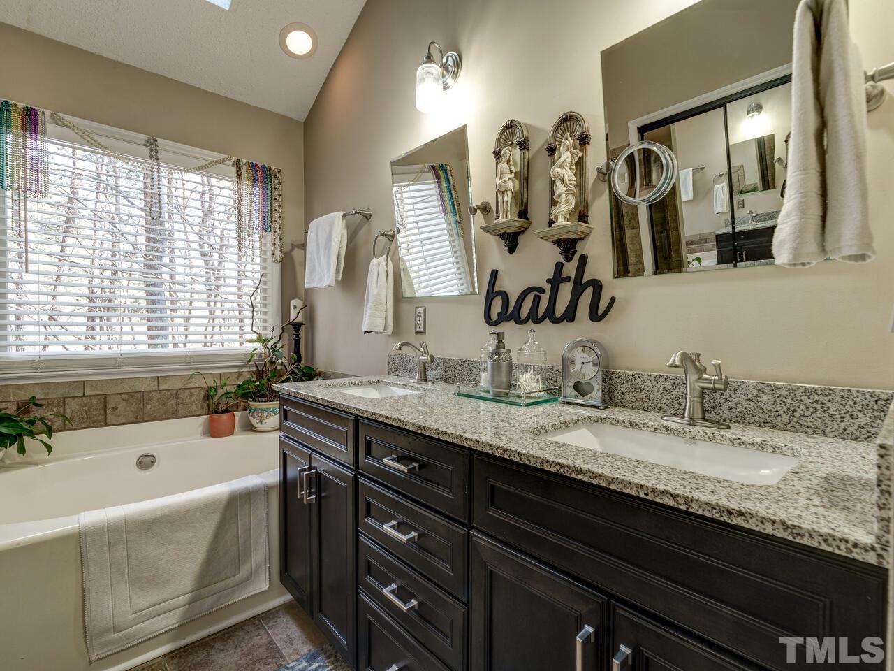 5933 Dunbarton Way Raleigh, NC 27613 - Photo 5 of 48 a bathroom with a granite countertop sink mirror and bathtub