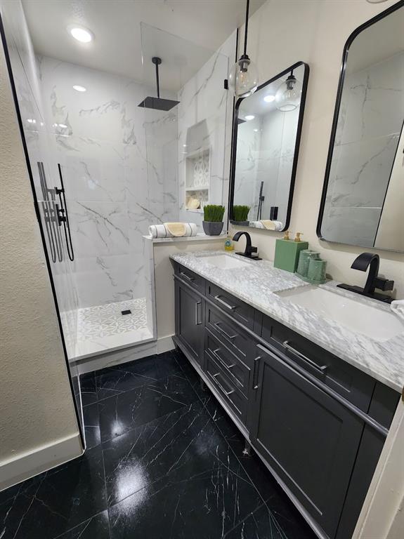 2908 Washington Street Commerce, TX 75428 - Photo 39 of 40 Modern bathroom featuring a spacious shower with black rain showerhead, white marble-look wall tile, and geometric pattern floor tile