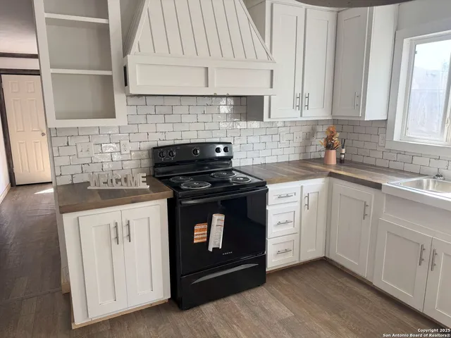 a kitchen with white cabinets and appliances
