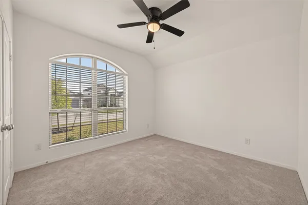 an empty room with windows and fan