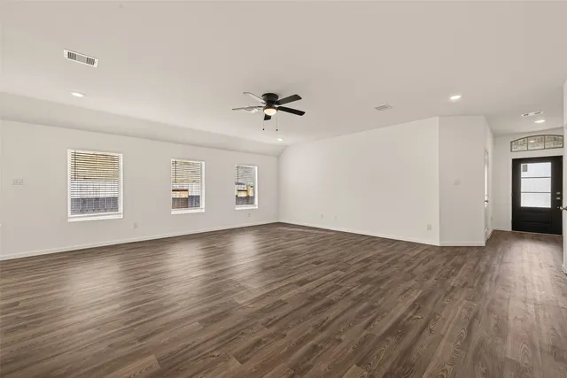 a view of a livingroom with wooden floor and a ceiling fan
