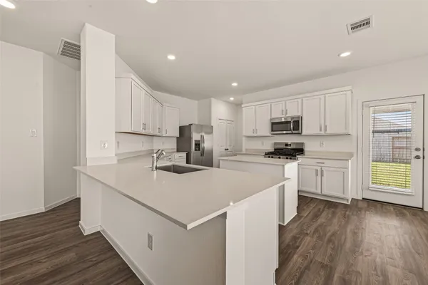 a kitchen with white cabinets sink and white stainless steel appliances