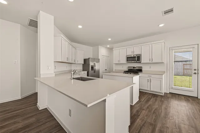 a kitchen with white cabinets sink and white stainless steel appliances