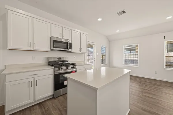 a kitchen with stainless steel appliances granite countertop a sink stove and microwave