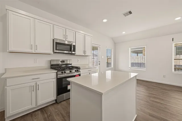 a kitchen with stainless steel appliances granite countertop a sink stove and microwave