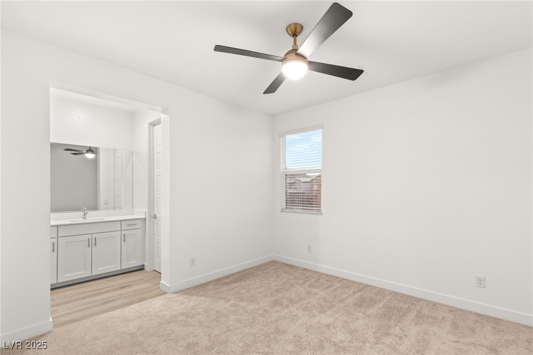 522 Riley Ridge Henderson, NV 89012 - Photo 33 of 53 Unfurnished bedroom with a sink, connected bathroom, baseboards, light colored carpet, and ceiling fan