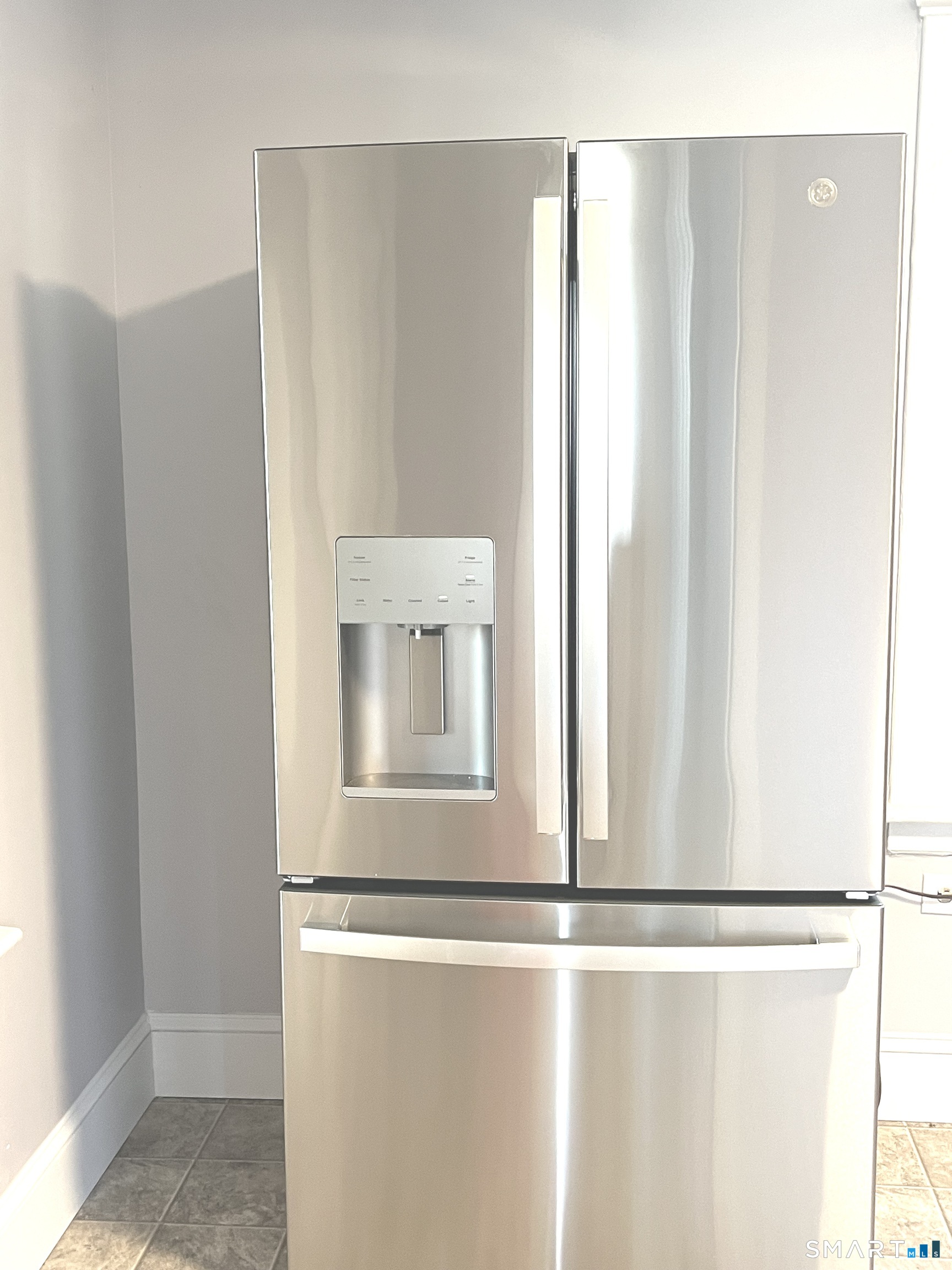 65 Chambers Street, Unit 1 Waterbury, CT 06708 - Photo 5 of 11 a room with a refrigerator and mirror